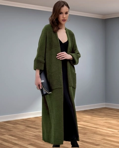Detail view of olive green knit cardigan with large pockets and ribbed cuffs