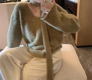 Detail of moss green faux mink hair sweater showing V-neck and matching scarf texture