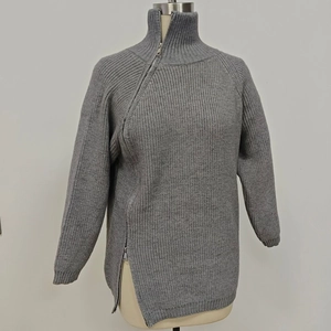 Dettaglio maglione grigio a maglia grossa con cerniera diagonale e maniche a raglan