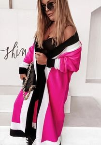 Detailed view of heavy knit long cardigan featuring bold pink and black color-block panels