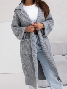 Dettaglio del cardigan grigio a maglia grossa con ampi revers e grandi tasche applicate