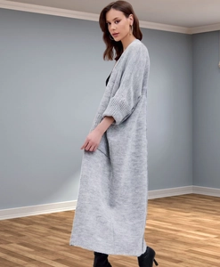 Detail of grey knitted cardigan showing ribbed cuffs and long oversized fit texture