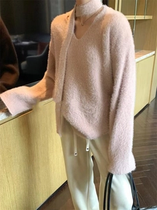 Detail of soft pink faux mink knit sweater featuring a stylish V-neck with a matching scarf