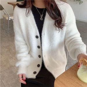 Détail du cardigan blanc en imitation vison avec col en V et boutons contrastants