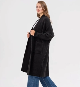 Detail view of black knit cardigan with ribbed cuffs and large functional side pockets