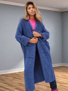 Detail of blue chunky knit cardigan featuring large front pockets and cuffed sleeves
