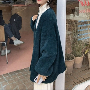 Détail du cardigan en imitation vison vert foncé avec une coupe oversize douce