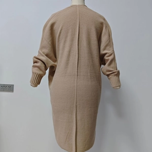 Detail view of apricot knit cardigan featuring ribbed cuffs and a vertical back seam design