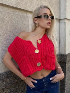 Macro detail of red chunky knit vest with three large gold buttons and deep V-neckline