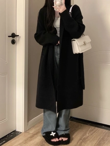 Mirror selfie showing a black long cardigan paired with light blue wide-leg jeans and bag