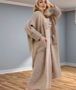 Detail of the oversized camel knit cardigan featuring large side pockets and ribbed cuffs
