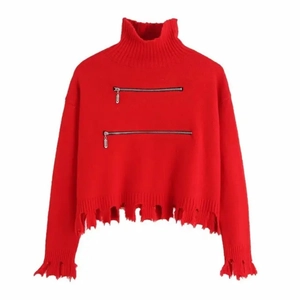 Dettaglio maglione rosso a collo alto con cerniere metalliche e orlo sfrangiato effetto usato