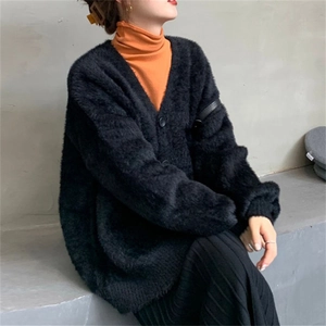 Détail du cardigan noir doux en imitation vison avec col en V et texture peluche