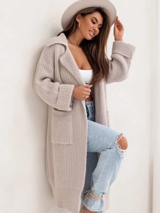 Dettaglio del revers oversize e della spessa trama a maglia a coste sul cardigan beige