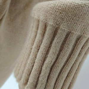 Detailed macro view of oatmeal knit sweater showing premium ribbed cuffs and fine texture