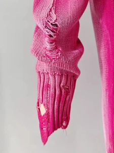 Distressed hot pink knit sweater featuring ripped details and vintage texture