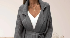 Detail of grey ribbed knit cardigan featuring classic lapel collar and waist tie belt