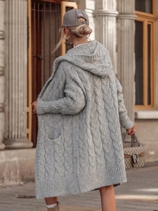 Detail shot of grey long hooded knit cardigan with classic cable-knit texture and side pockets
