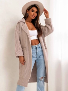 Dettaglio del cardigan in maglia color avena con ampi revers e trama morbida da donna