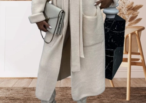 Detail of soft cream white knit cardigan showing vertical ribbing texture and large pocket