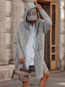 Macro detail of chunky grey cable knit texture and hooded design on long cardigan