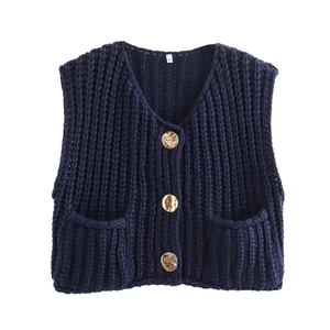 Detail of navy knit vest with three gold embossed buttons and square front pockets