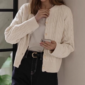 Detail of cable knit cardigan featuring premium golden buttons and chunky texture
