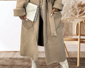 Detail of camel knit cardigan showing ribbed texture, large side pockets, and matching belt