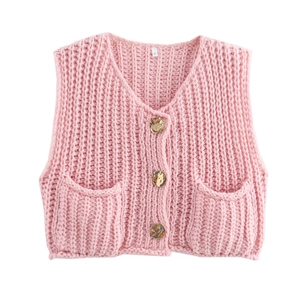 Close-up of pink cable knit vest featuring vintage gold buttons and front pockets
