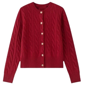 Detail of red cable knit cardigan showing texture, round neck and wooden buttons