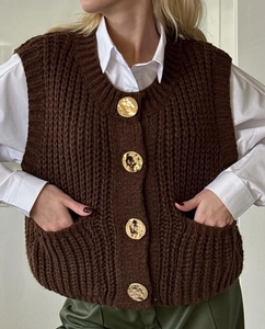 Close-up of deep brown chunky knit vest with four vintage gold embossed buttons