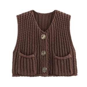 Close-up of thick knit vest showing V-neckline, metal buttons and large front pockets