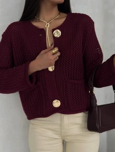 Détail du cardigan en maille bordeaux avec boutons dorés vintage et texture ajourée