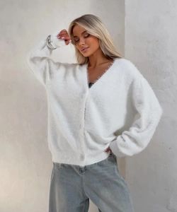 Dettaglio della trama del cardigan bianco in finta pelliccia con morbide fibre e bottoni