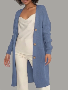Detail of haze blue knit cardigan featuring wooden buttons and soft textured side pockets
