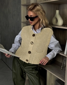 Detail view of beige knit vest featuring four vintage metal buttons and thick knit texture