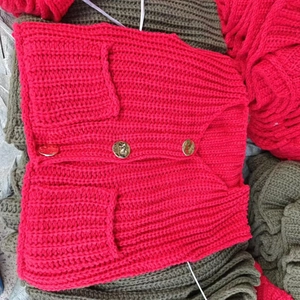 Detailed macro view of magenta crochet knit vest featuring textured gold round buttons