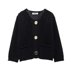 Détail du cardigan noir ajouré avec de gros boutons dorés et des poches texturées