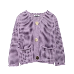 Détail de gilet en maille ajourée violette avec de gros boutons dorés élégants