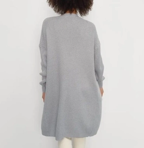 Rear view of a loose grey knit cardigan showing thick texture and relaxed fit style