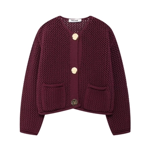 Détails de la maille du cardigan bordeaux ajouré avec de gros boutons dorés