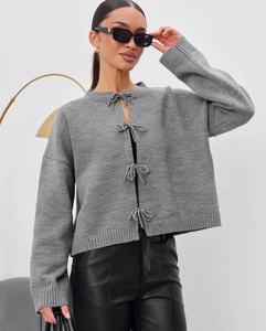 Detailed close-up of grey knitted cardigan with four delicate handmade bow tie closures
