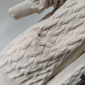 Close-up of cable knit texture and pocket detail on this beige knit cardigan sweater