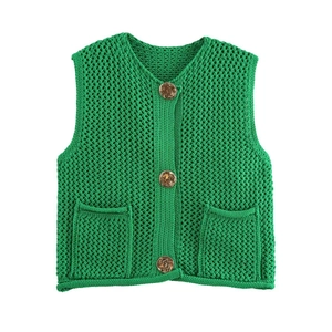 Detalle del chaleco de ganchillo verde con punto calado, cuello en V y tres botones ámbar