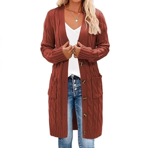 Dettaglio di un lungo cardigan in maglia a trecce rosso ruggine con tasche laterali e bottoni