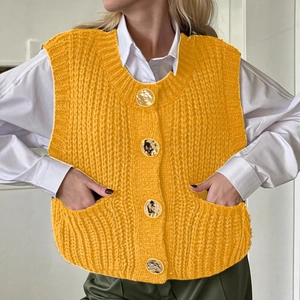 Women's bright yellow knitted vest with round neck and gold buttons over white shirt