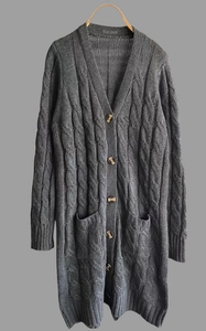 Dettaglio del cardigan grigio antracite a maglia intrecciata con bottoni in legno e tasche