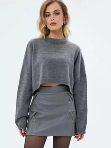 Detail of grey cropped knit sweater with matching leather mini skirt and side lacing