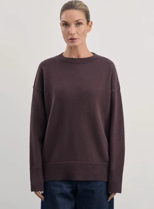 Detail of loose fit dark purple crew neck sweater with soft wool knit texture