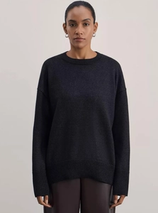 Detail of loose fit dark grey round neck knit sweater with dropped shoulder seams